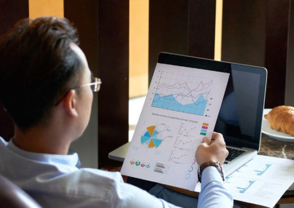rear-view-man-seated-armchair-cafe-analyzing-diagrams-charts-before-presentation